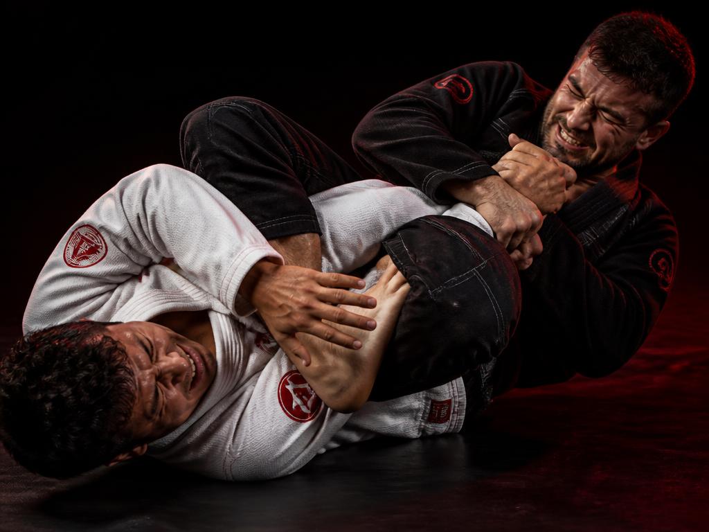 Dois atletas treinando uma finalização no tatame